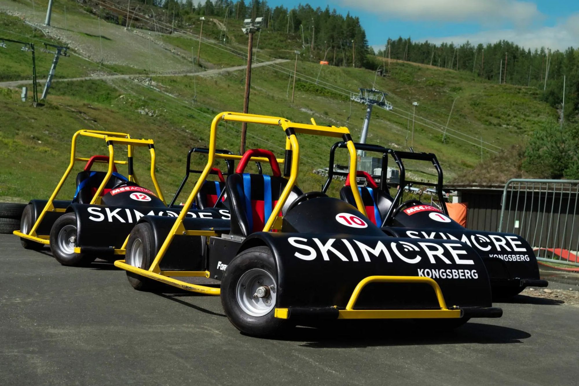 Go-kart-biler fra Skimore Kongsberg parkert på asfalt foran skibakken