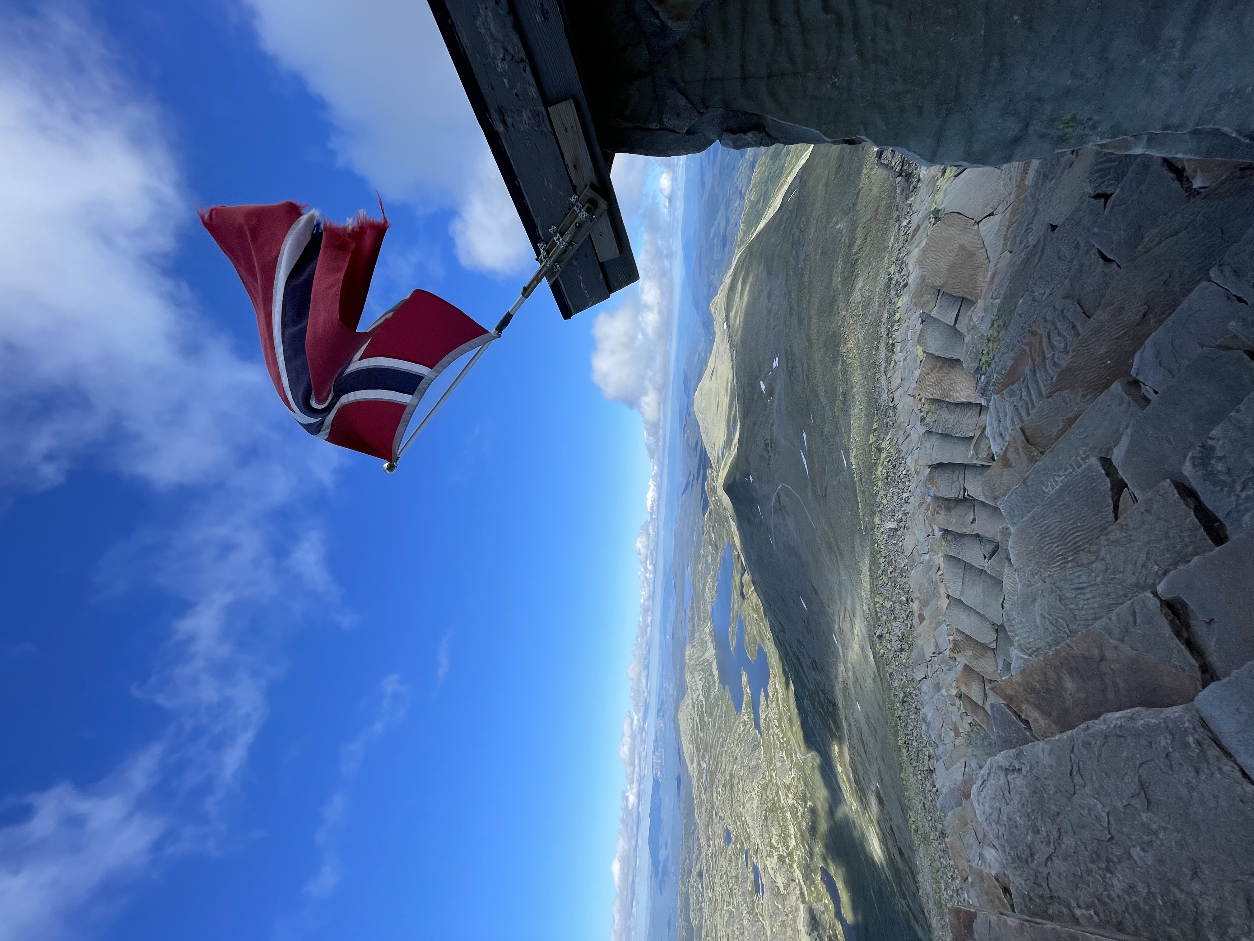 Gaustatoppen turisthytte med norsk flagg og utsikt