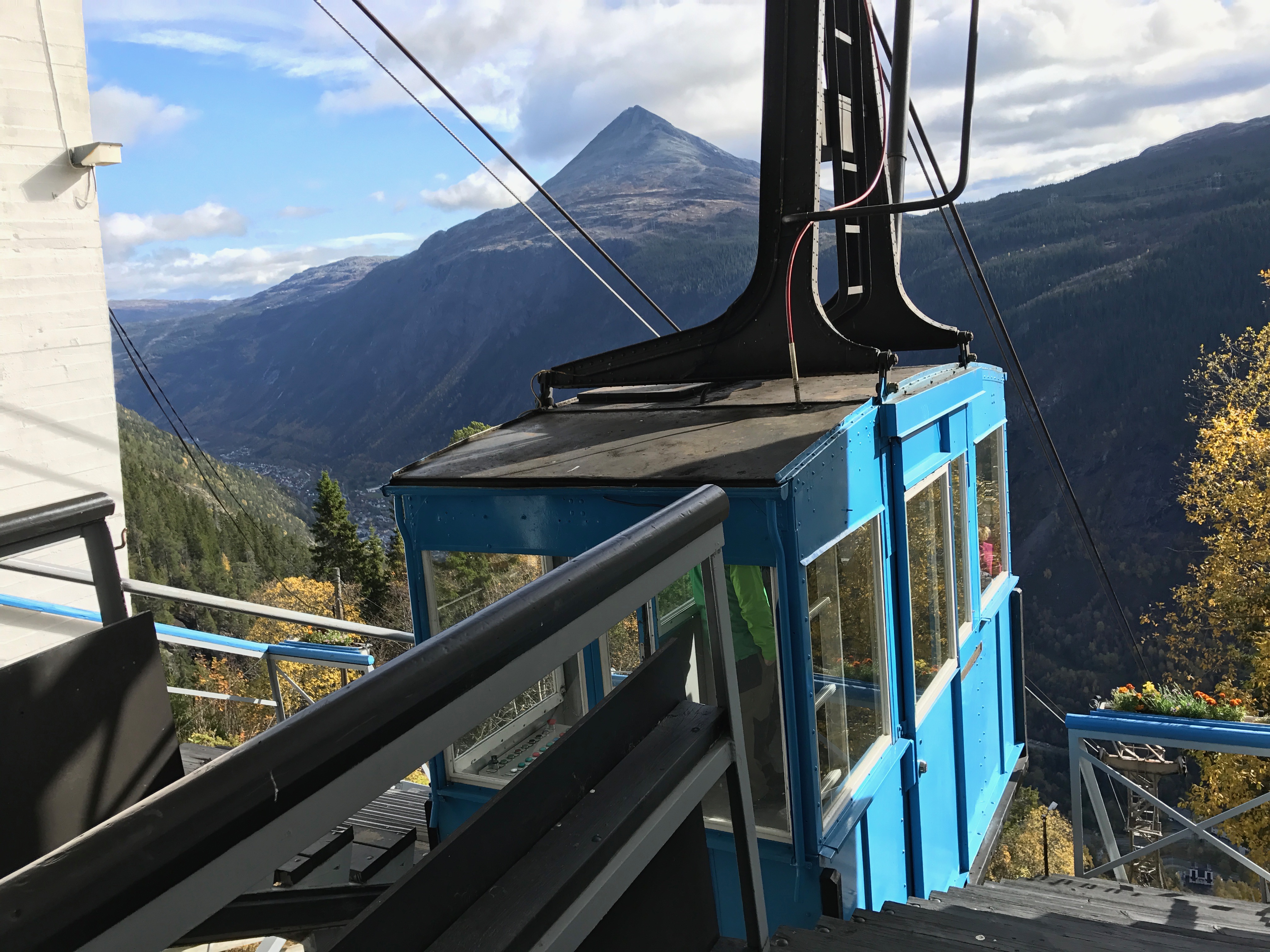 Blå Krossobanen-vogn på toppstasjonen med utsikt over Rjukan-dalen