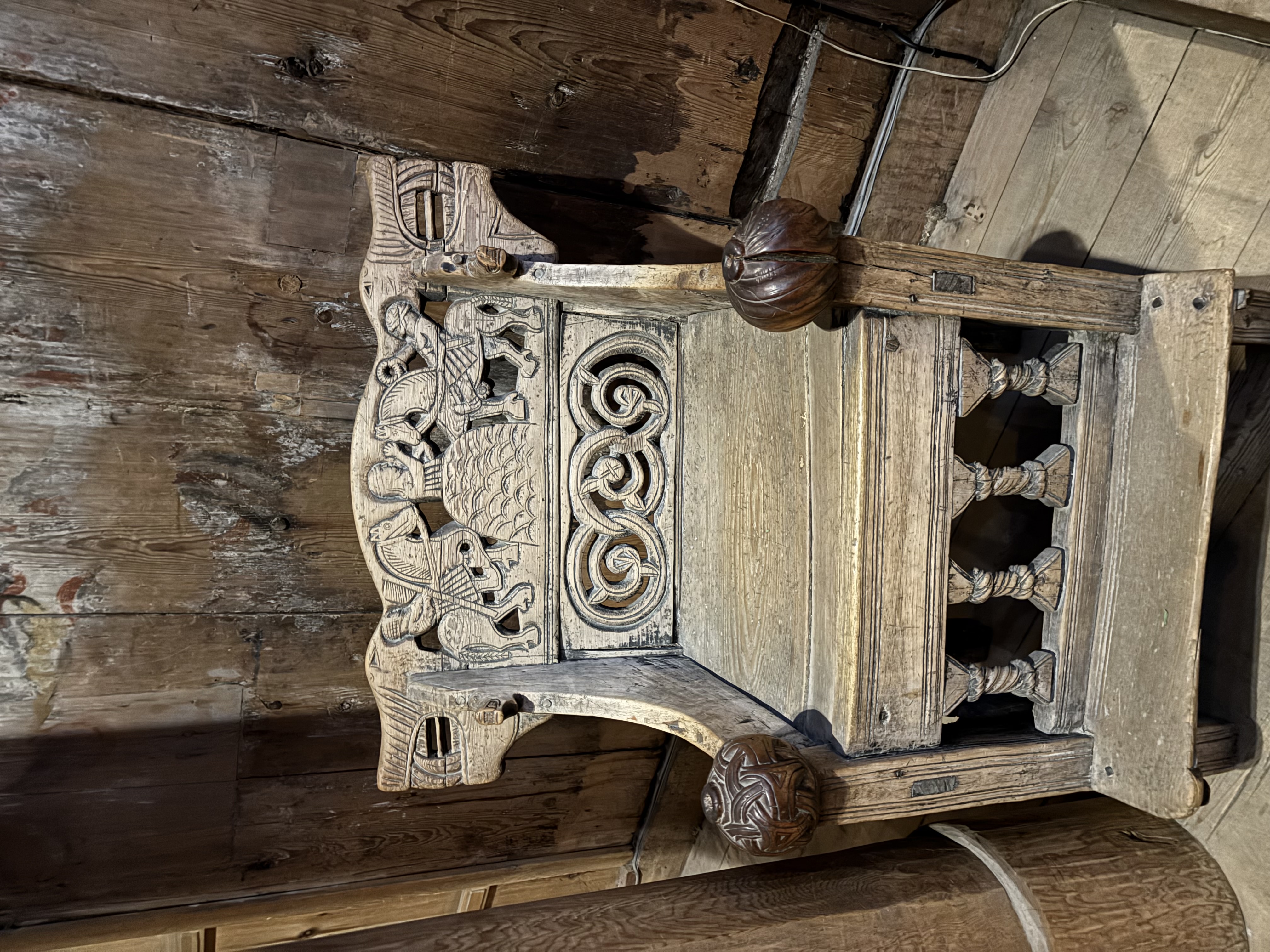 Middelaldersk treskåret biskopsstol i Heddal stavkirke med utskjæringer av ryttere og slyngende dragefigurer